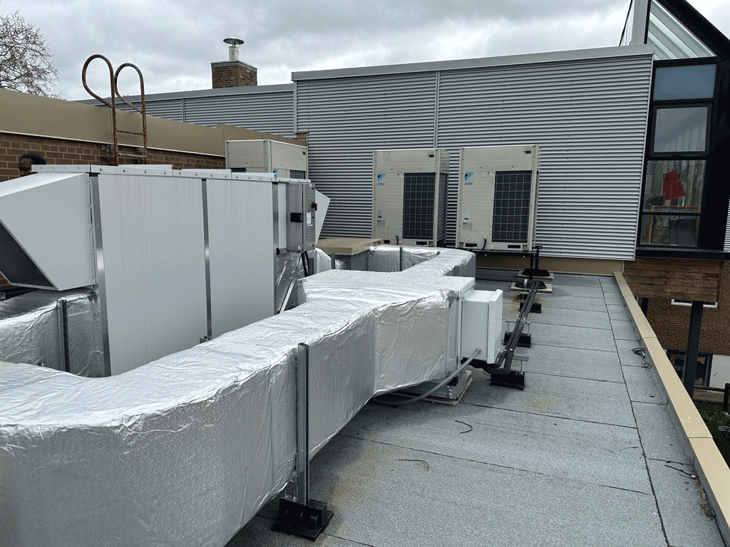 Image of the HVAC system on the roof of a building, including a Daikin Aurora Heat Recovery VRF System.