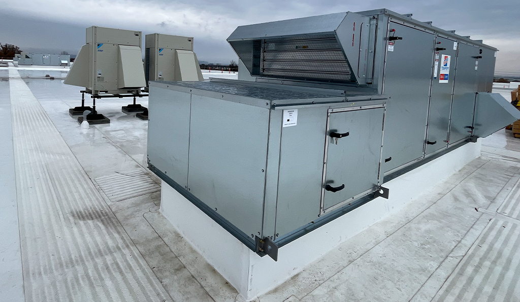 Image of the Tempeff Energy Recovery Ventilators (ERVs) on the rooftop of Derry Green Industrial. Behind the Tempeff units are the Daikin VRF Condensing Units.