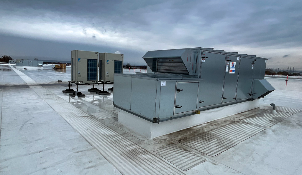 Image of the Tempeff Energy Recovery Ventilators (ERVs) on the rooftop of Derry Green Industrial. Behind the Tempeff units are the Daikin VRF Condensing Units.