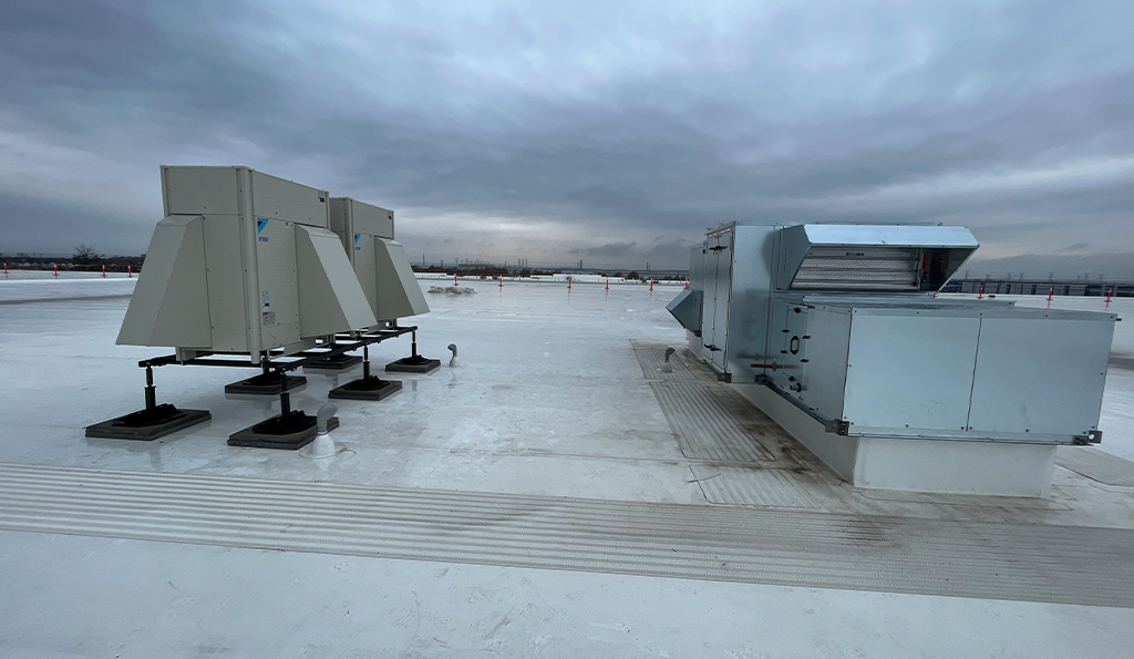 Image of the Tempeff Energy Recovery Ventilators (ERVs) on the rooftop of Derry Green Industrial. Behind the Tempeff units are the Daikin VRF Condensing Units.