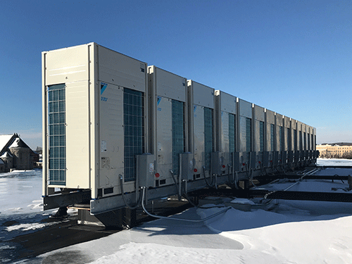 Photo of Daikin VRV-IV outdoor units installed on snowy rooftop with custom roof rails