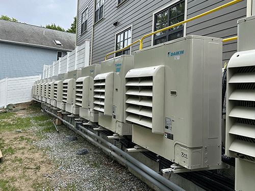 Multiple Daikin Cold Climate Split Systems serving residential suites along the side of the building