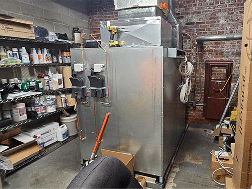 Photo of Daikin Preciseline Air Handling Unit with integral VRV coil, installed in a storage room with visible ductwork and tools