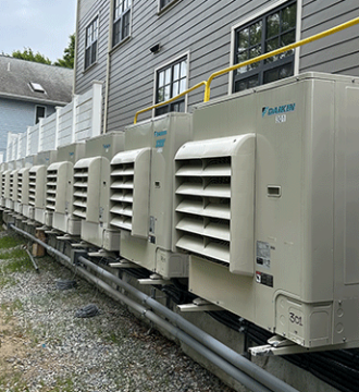 Multiple Daikin Cold Climate Split Systems serving residential suites along the side of the building